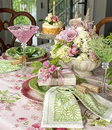 A Table Topped With Plates Covered In Pink And Green Flowers