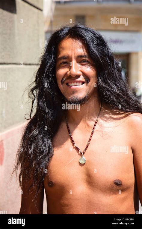 City Portrait Of Young Latino Man With Long Hair And Jewelry Stock