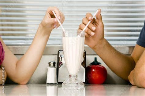 Teenage Couple Sharing A Milkshake Stock Photo And Royalty Free