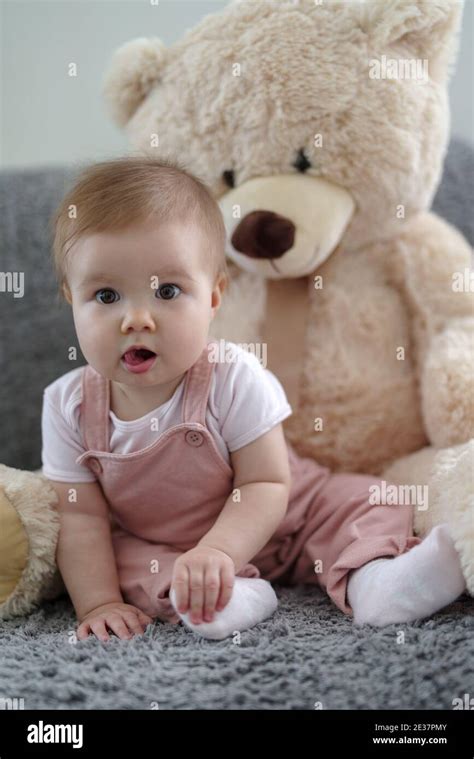 Baby Girl In Bed Next To Giant Soft Toy Bear Stock Photo Alamy