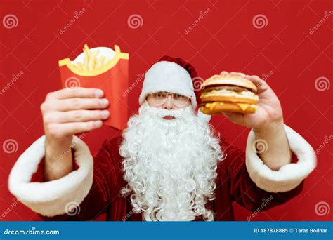Portrait Of Santa Claus With Fast Food In Her Hands Isolated On Red