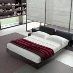 Modern And Spacious Bedroom With Gray Tempurpedic Sofa Bed With White Bolster And Red Sheet On Gray Area Rug With Open Racks And Floor Lamp 150x150 