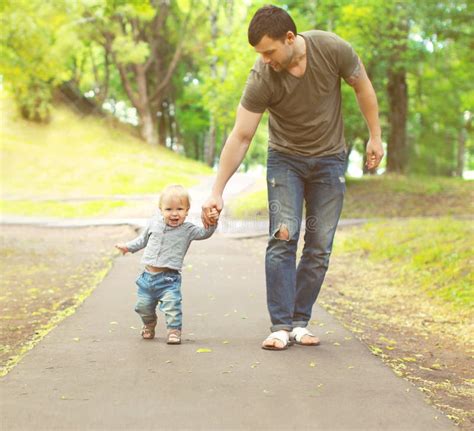 El Padre Joven Y El Hijo Que Caminan En Verano Parquean Foto De Archivo
