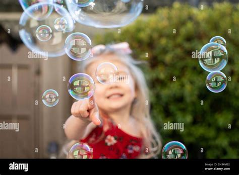 Little Girl Playing With Bubbles Happy Child Popping Bubbles Stock