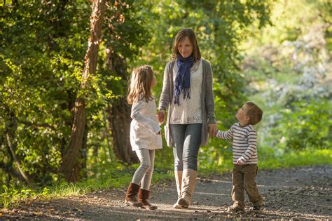 Mother Walking With Her Children On Forest Track Stock Photo