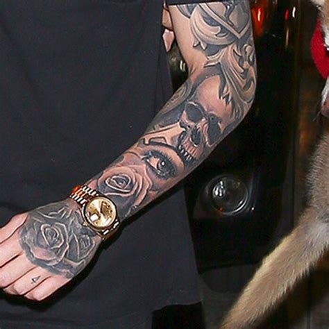 One tattoo appeared to be a skull and roses design whilst the other shows a silhouette of a bird of prey flying in front of the sun. That eye looks familiar.... #liampayne #onedirection # ...