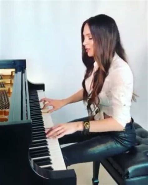 A Woman Sitting At A Piano With Her Hands On The Keys