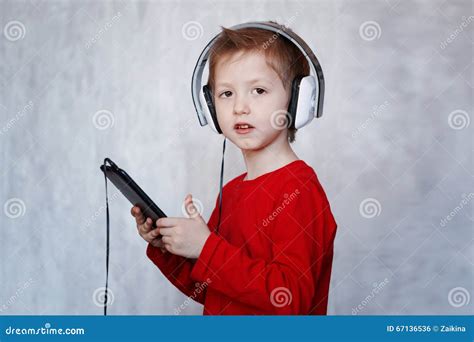 Niño Pequeño Con Las Auriculares Usando La Almohadilla Táctil
