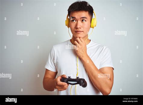 Young Asian Chinese Gamer Man Playing Video Game Standing Over Isolated