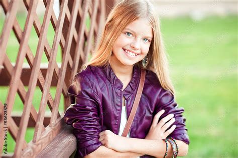 Smiling Blonde Girl 13 15 Year Old Wearing Trendy Jacket Outdoors Over Green Nature Background