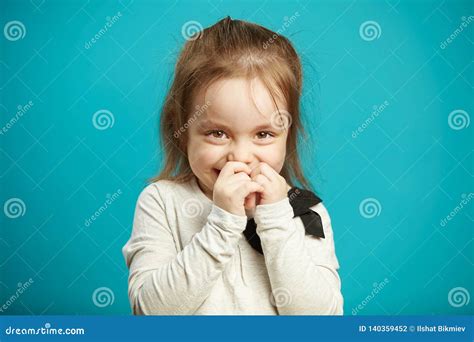 Little Shy Girl Smiles And Covers Her Mouth With Hands Expresses