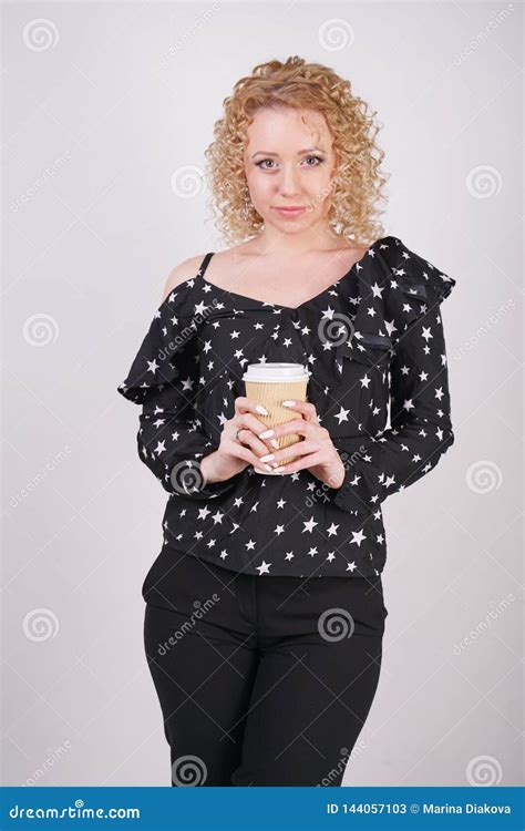 Cute Curly Blonde Girl Stands In Black Fashionable Clothes And Holds A