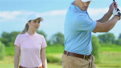 Woman Golf Beginner Player Admiring Man Professionally Hitting Ball