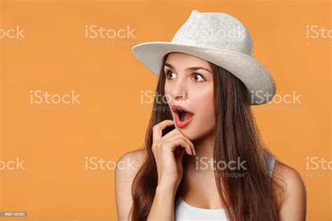 Surprised Happy Beautiful Woman Looking Sideways In Excitement Isolated On Orange Background