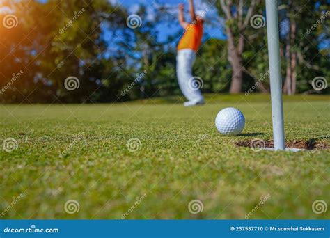 Golfer Putting Ball On The Green Golf Lens Flare On Sun Set Evening