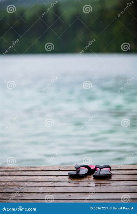 Flip Flops On A Dock In Front Of A Turquoise Water Lake Stock Photo