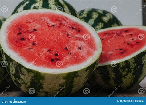 Red Ripe Cut Watermelon Against Background Of Whole Watermelons Stock