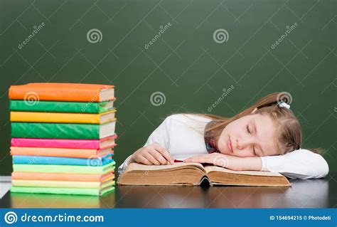 Colegiala Que Duerme En El Libro En Sala De Clase Imagen De Archivo