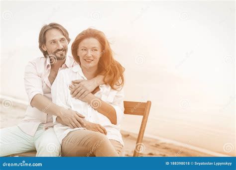 Happy Mature Couple Hugs Sitting In Beach Cafe At Sea Side Portrait Of Hugging Pretty Two