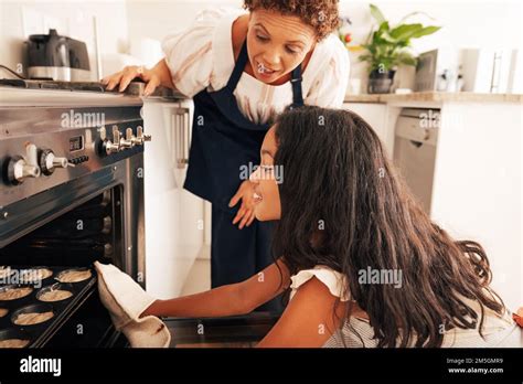 Girl And Granny Cook Together Grandmother Teaching Granddaughter How To Bake Cupcakes In The
