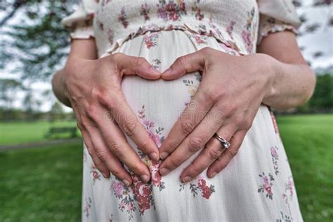 closeup shot of the pregnant female making heart gesture on her belly stock image image of