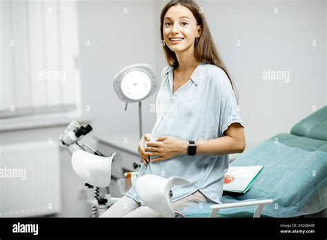 Smiling Pregnant Woman Sitting On The Gynecological Chair Before A Medical Examination By A