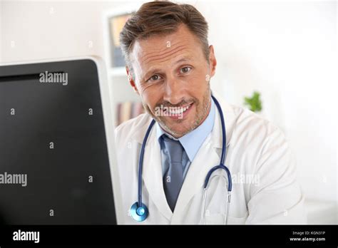 Portrait Of Doctor Sitting In Front Of Computer Stock Photo Alamy