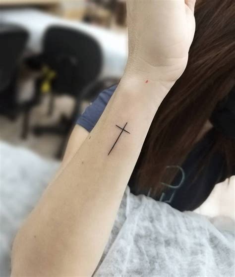 Minimalistic Style Cross Tattoo Located On The Wrist