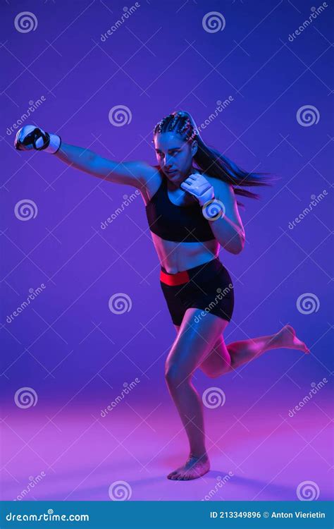 Athletic Female Mma Fighter Over Blue Pink Background In Neon Light