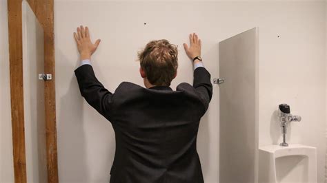 unquestioned alpha of the bathroom this guy has both hands up on the wall over the urinal and