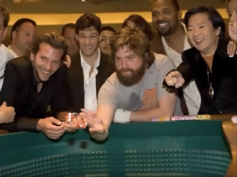 A Group Of Men Standing Around Each Other In Front Of A Table