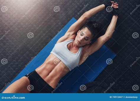 Muscular Woman Doing Stretching Workout On Exercise Mat Stock Image