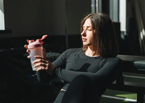 Portrait Of Resting Young Brunette Woman In Sport Active Wear Drinking