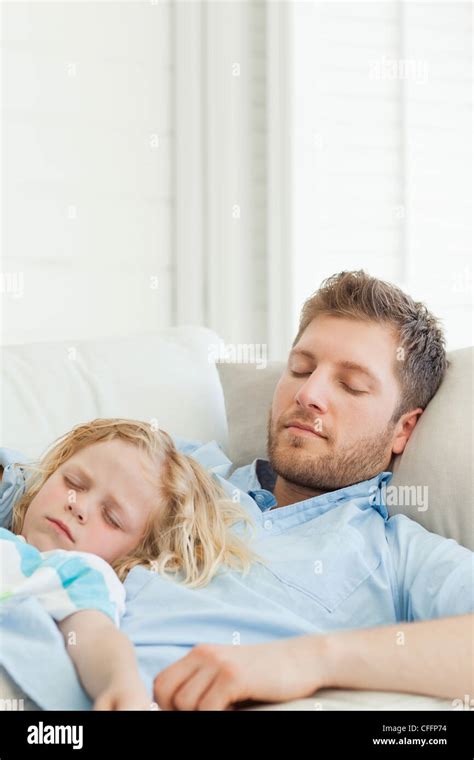 Father With His Son Lying On Top Of Him As They Sleep On The Couch Stock Photo Alamy