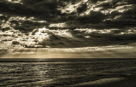 Sun Rays Shining Through The Clouds Over Ocean Photograph