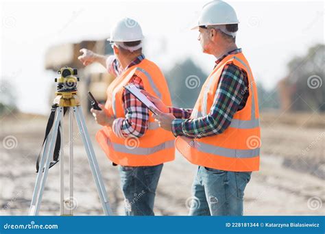 Road Construction Workers Using Measuring Device On The Field Stock