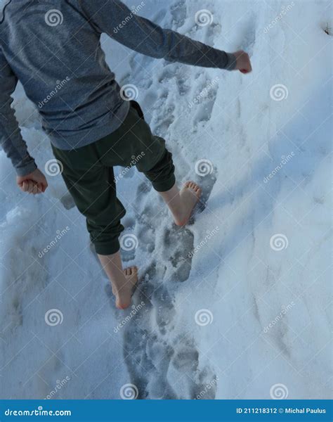 Schoolboy Boy Walks Barefoot Through The Snow Covering The School Yard