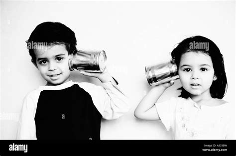 Children Talk To Each Other With Toy Tin Can Telephone Stock Photo Alamy