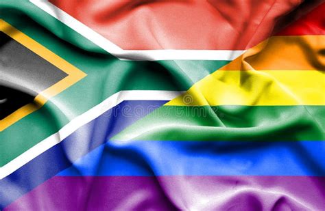 gay pride of south africa flag textile cloth fabric waving on the top sunrise mist fog stock