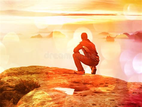 Tourist Sit On Peak Of Sandstone Rock And Watching Into Colorful Mist