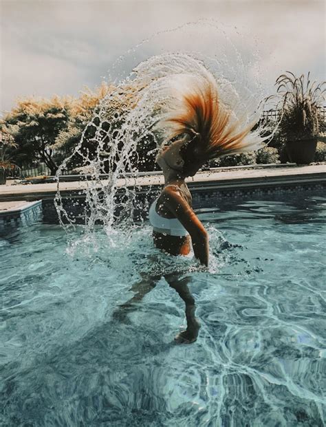 A Woman Splashing Water In A Pool With Her Hair Back And White Shirt On