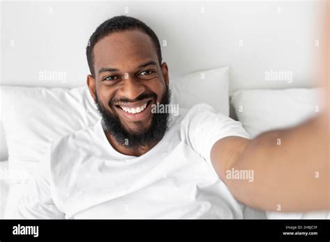 Smiling Millennial African American Bearded Man Looks At Webcam Lies