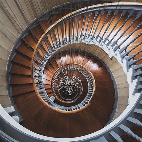 An Overhead View Of A Spiral Staircase With Wooden Railing And