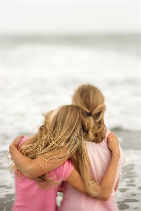 Rear View Of A Mother And Daughter Embracing At The Beach Vertical