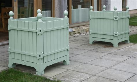 The 'versailles', or orange tree planter is a stunning planter with ball finials and mouldings to give it a truly classic look. Two 'Versailles' painted wood and metal planter boxes,by Les Jardins du Roi Soleil, with detachab