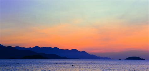Free Photo Silhouette Of Mountain Beside Ocean During Orange Sunset