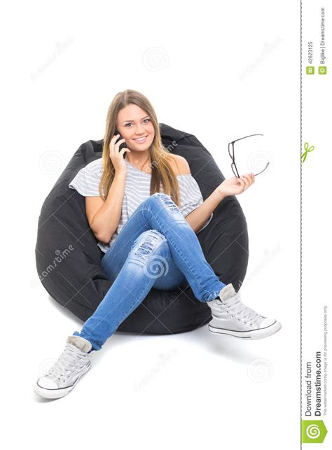 Cute Teenage Girl Talking On The Phone Sitting On Beanbag Stock Image