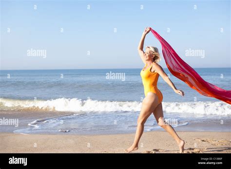 Senior Woman Walking On Beach Stock Photo Alamy