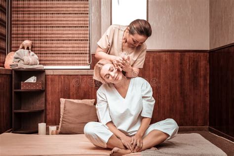 massaggiatrice che fa massaggio delle natiche per il suo cliente fotografia stock immagine di