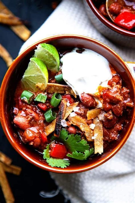Two Bowls Filled With Chili Beans And Sour Cream